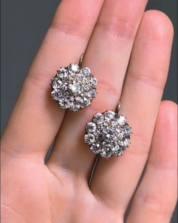 A pair of diamond cluster dormeuse earrings, of circular two tiered design mounted in 18kt gold. Available @simonteaklejewelry #dormeuseearrings #dormeusediamondearrings #diamondearrings #clusterearrings #diamondsclusterearrings #simonteaklejewelry #
