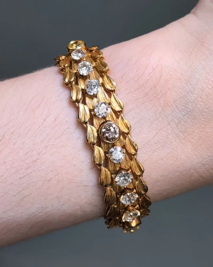An 18kt gold and diamond bracelet by Julius Cohen, designed as a single row of twenty five circular cut colorless and colored diamonds, spaced within texture foliate links. New York circa 1980. Available @simonteaklejewelry #juliuscohen #juliuscohenb