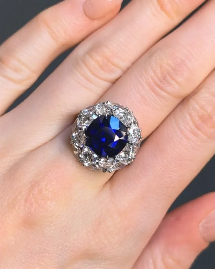 A cushion shaped 7.06ct sapphire and diamond cluster ring, the central sapphire with a navette and heart shaped diamond two tiered surround, mounted in platinum. Available @simonteaklejewelry #sapphirering #sapphireanddiamondring #sapphirediamondclus