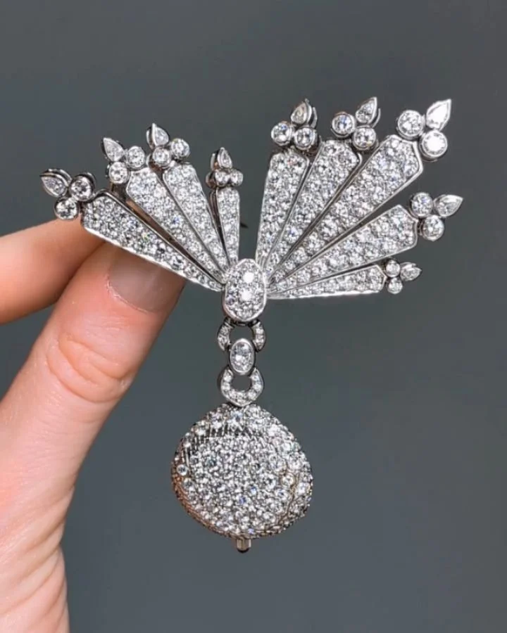 A diamond brooch watch by Van Cleef &amp; Arpels, the circular pave set diamond pendant watch suspended from a sunburst spray motif, mounted in 18kt white gold. Paris circa 1990. Available @simonteaklejewelry #vancleefarpels #vancleefjewelry #vanclee