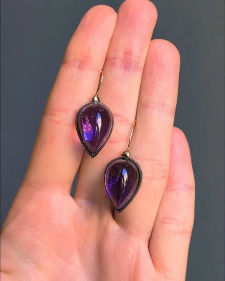A pair of cabochon amethyst and diamond earrings, each inverted pear shaped amethyst drop, mounted in silver and gold with a diamond set gallery. Available @simonteaklejewelry #amethystearrings #amethystdrops #dropearrings #cabochonamethyst #amethyst