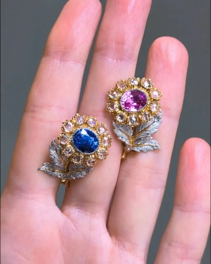 A pair of colored sapphire and diamond earrings by Buccellati, each designed as a floral spray motif, one with a central blue sapphire the other with a pink sapphire with a rose cut diamond surround, mounted in 18kt yellow and white gold. Available @