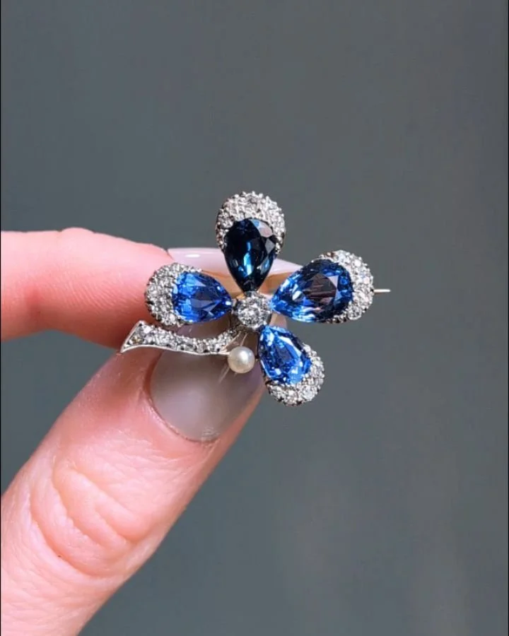 An antique sapphire and diamond four leaf clover pin, set with pear shaped sapphires with a part diamond surround and single pearl detail, mounted in silver and gold. Circa 1890. Available @simonteaklejewelry #antiquebrooch #antiquesapphirebrooch #an