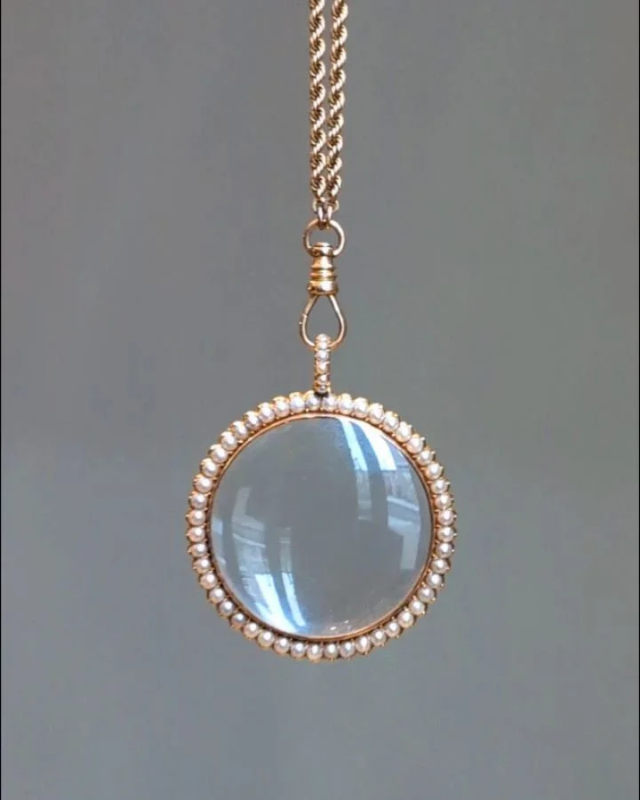 An antique natural pearl magnifying pendant, the circular glass center bordered on both sides by natural half pearls mounted in 18kt gold. English circa 1820. Available @simonteaklejewelry #naturalpearls #antiquepearlpendant #georgianjewelry #goergia