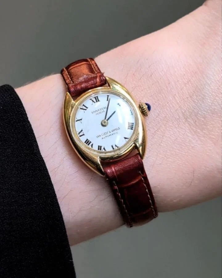A Lady's 18kt gold watch by Van Cleef &amp; Arpels, the circular white enamel dial with roman numerals, automatic movement, on a brown leather band. Circa 1970. Available @simonteaklejewelry #vca #vancleefandarpels #vcawatch #vintagewatch #vintagevca