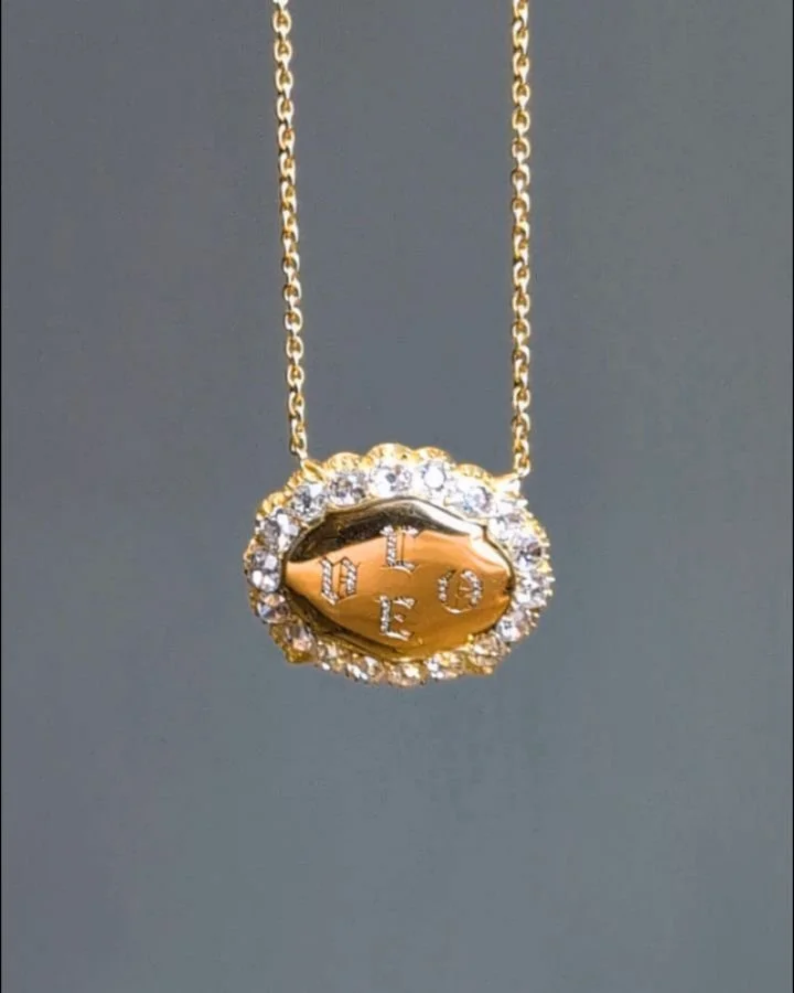A diamond pendant, the antique oval mount with a central gold panel, diamond set with the word &quot;LOVE&quot;, mounted in 18kt gold on a fine link chain. Available @simonteaklejewelry #diamondpendant #diamondlove #lovependant #goldanddiamondpendant