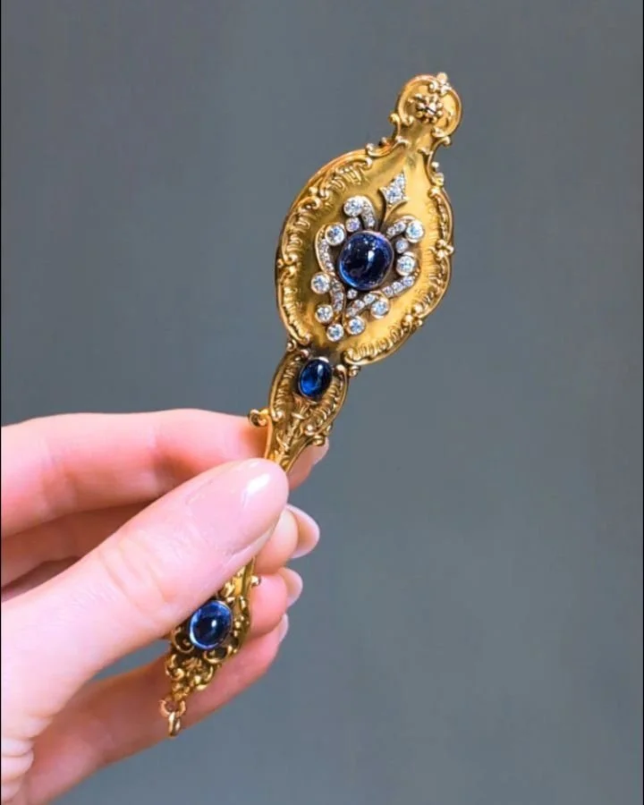 A pair of Belle Epoque gold lorgnettes, the scroll chased gold frame with cabochon sapphire and circular cut diamond scroll motifs. Circa 1900. Available @simonteaklejewelry #belleepoque #belleepoquelorgnettes #belleepoquebeauty #antiquelorgnettes #l