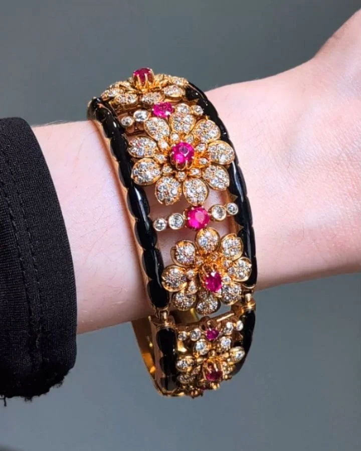 An antique ruby and diamond bracelet, designed as a series of five graduated cluster detachable flowerheads with five stone line intersections within an articulated black enamel and 18kt gold frame. Circa 1880. Available @simonteaklejewelry #victoria