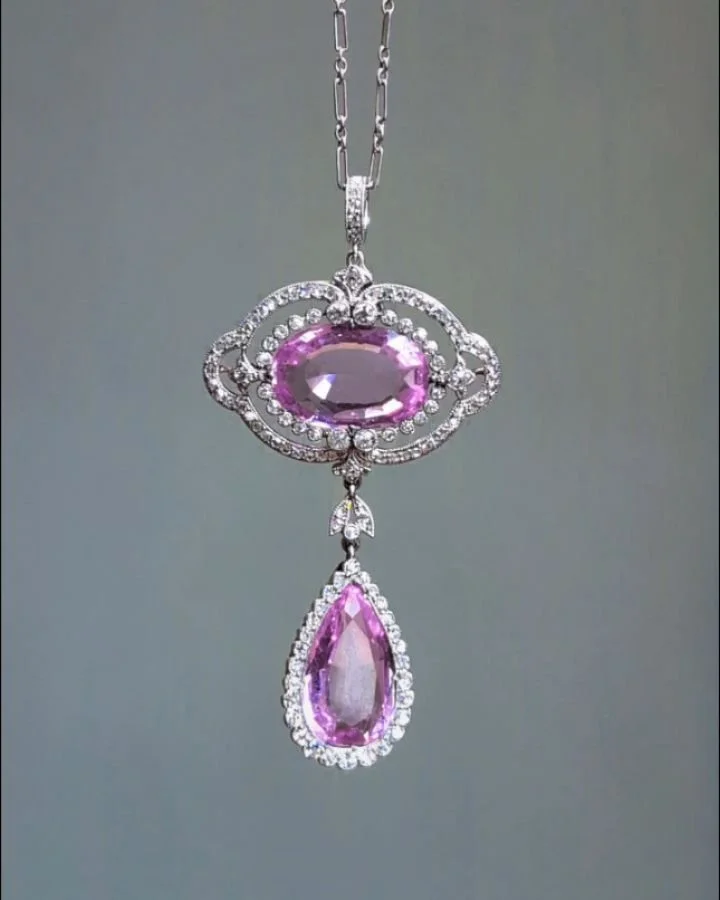 A Belle Epoque pink topaz and diamond pendant brooch, the open oval panel with a pear shaped drop, mounted in platinum, with detachable brooch and pendant fittings. Available @simonteaklejewelry #pinktopaz #antiquepinktopaz #belleepoquependant #antiq