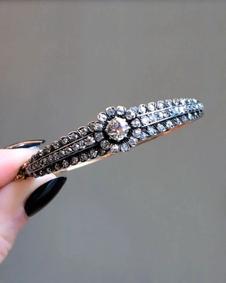 An antique diamond bangle, the central circular cluster with three row diamond shoulders, mounted in silver and gold. English circa 1880. Available @simonteaklejewelry #victorianjewelry #victorianjewellery #victorianbangle #antiquediamondbangle #vict