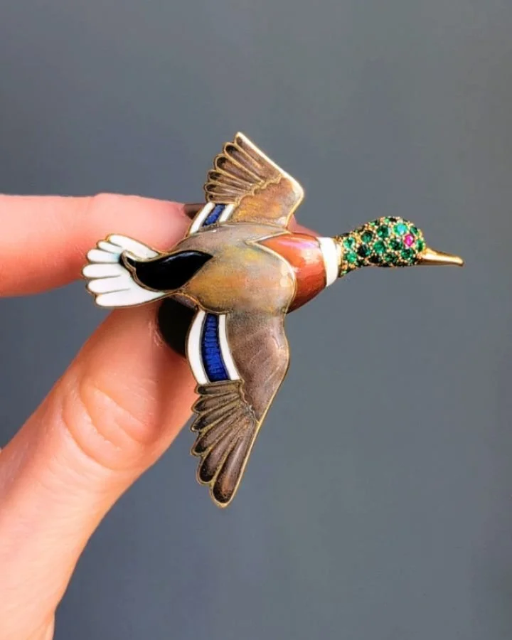 An enamel Mallard brooch by Cartier, the polychrome enamel wings and body with a pave set emerald head and single ruby eye, mounted in 18kt gold. Circa 1965. Available @simonteaklejewelry #vintagecartier #cartier #vintageanimalbrooch #vintagecartierb
