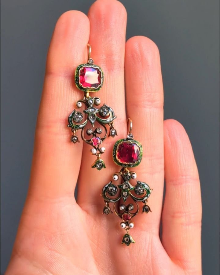 A pair of antique renaissance revival diamond earrings, each designed with a cushion shaped red paste suspending a green and white enamel scroll motif with rose cut diamond detail. Circa 1880. Available @simonteaklejewelry #pasteearrings #antiquepast