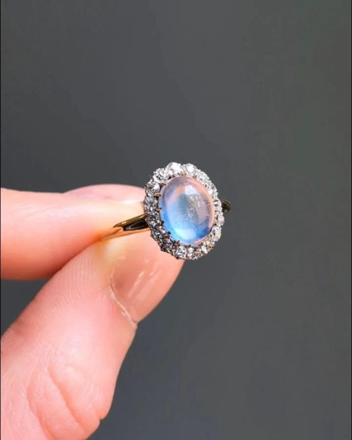 An antique moonstone and diamond cluster ring by Regnell Bigney &amp; Co, mounted in gold and platinum. Circa 1900. Available @simomteaklejewelry #antiquemoonstone #antiquemoonstonering #antiqueclusterring #antiquediamondring #regnellbigneycojewelry 