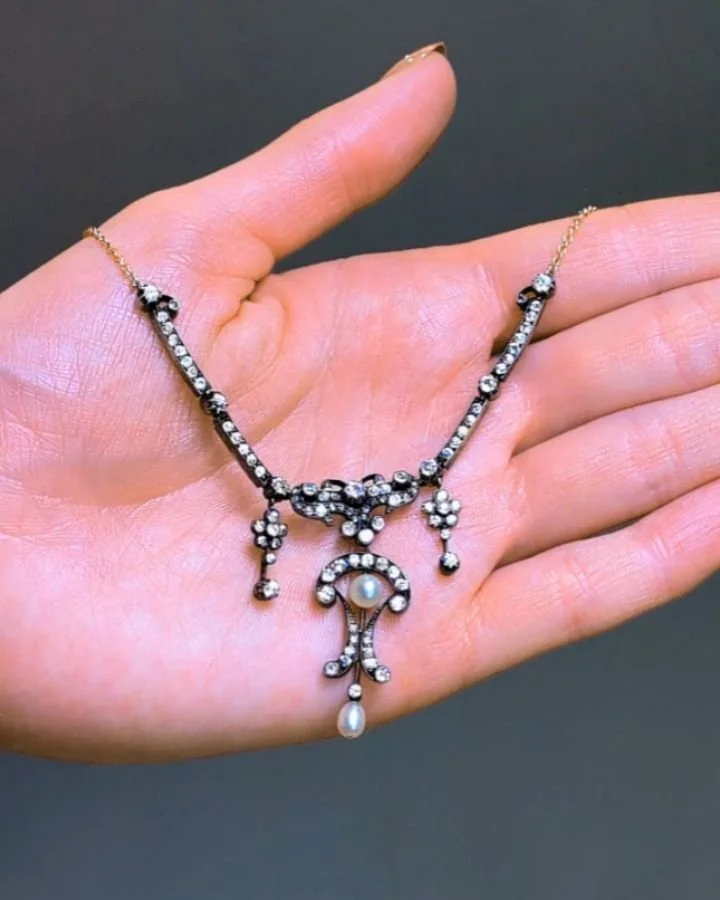 A Belle Epoque pearl and diamond necklace&nbsp; of scroll and foliate cluster design mounted in silver and gold on a fine link chain. Circa 1895. Available @simonteaklejewelry #belleepoque #belleepoquebeauty #belleepoquenecklce #naturalpearl #natural