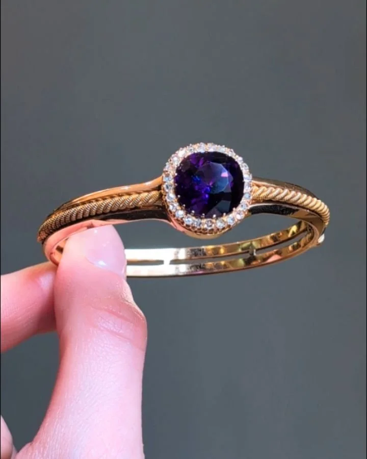 An antique amethyst and diamond bangle, designed with a central cushion shaped amethyst and old mine cut diamond cluster, on an open 14kt gold band with rope twist detail. Circa 1880. Available @simonteaklejewelry #antiqueamethyst #antiquebangle #vic