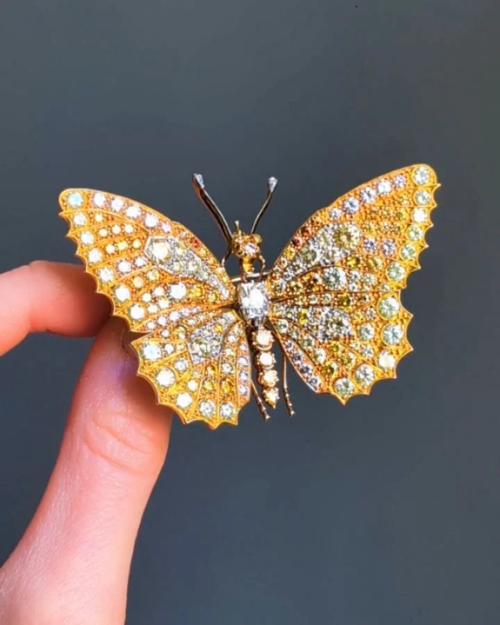 A multi colored diamond butterfly brooch, the pave set diamond wings set "en tremblant", single line body, mounted in 18kt gold, in a fitted Asprey box. English circa 1960. Available @simonteaklejewelry #entremblant #entremblantbrooch #vint