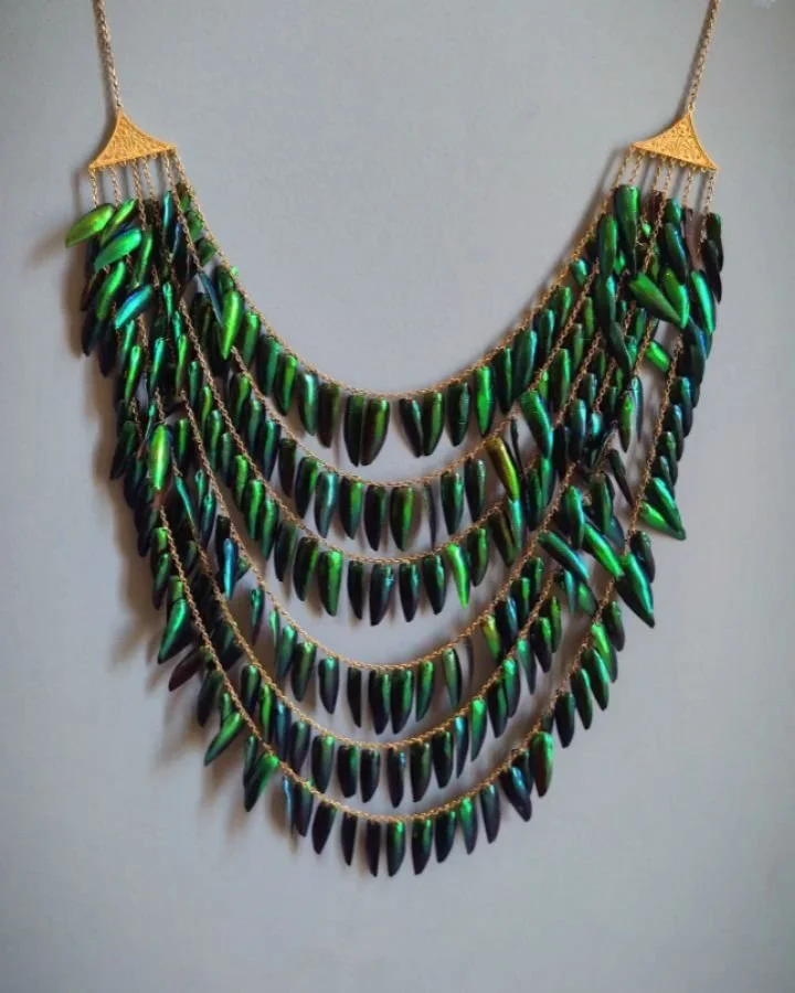 An antique Beetle wing bib necklace, designed with six row strands, the wings suspended from simple gold chains suspended from classical revival triangular cannetille panels. English circa 1870. Available @simonteaklejewelry #beetlewings #beetlewings