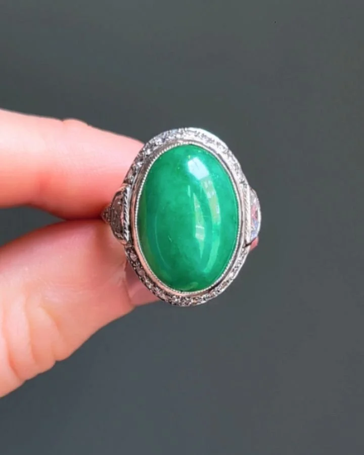An Art Deco jade and diamond ring, the oval shaped jade within a circular and half moon cut diamond platinum mount. Circa 1925. Available @simonteaklejewelry #jadering #artdecojade #artdecoring #artdecojewelry #artdecojadering #artdecojadediamondring