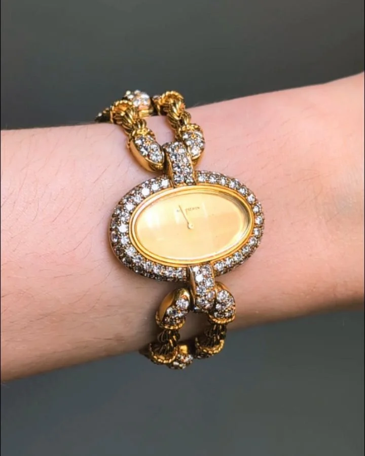 An 18kt gold and diamond watch by Boucheron, the horizontal oval gold dial within a pave set diamond frame on a twin rope twist bracelet and pave set diamond buckle motifs. Paris circa 1970. Available @simonteaklejewelry #boucheron #vintageboucheron 