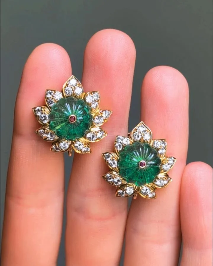A pair of emerald and diamond earrings by Van Cleef &amp; Arpels, each earrings in the mogul style set with a carved emerald bead, circular cut ruby detail and pave set diamond petal motif surround, mounted in 18kt gold. Circa 1970. Available @simont