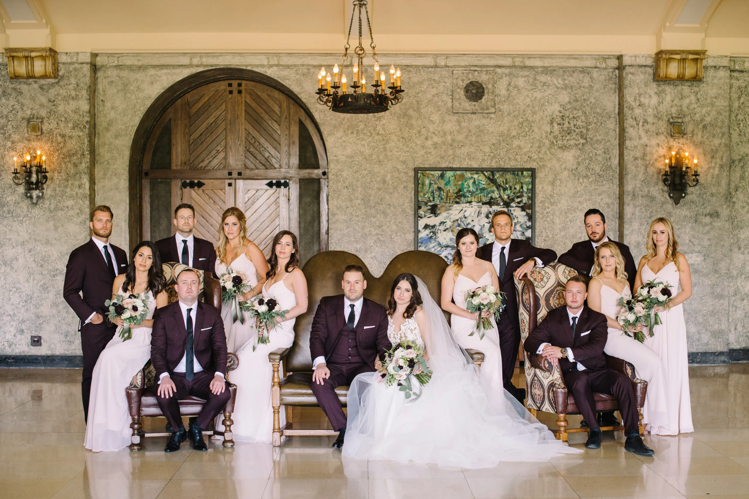 Wedding party with groom and groomsmen in custom burgundy suits by Atelier Suiting