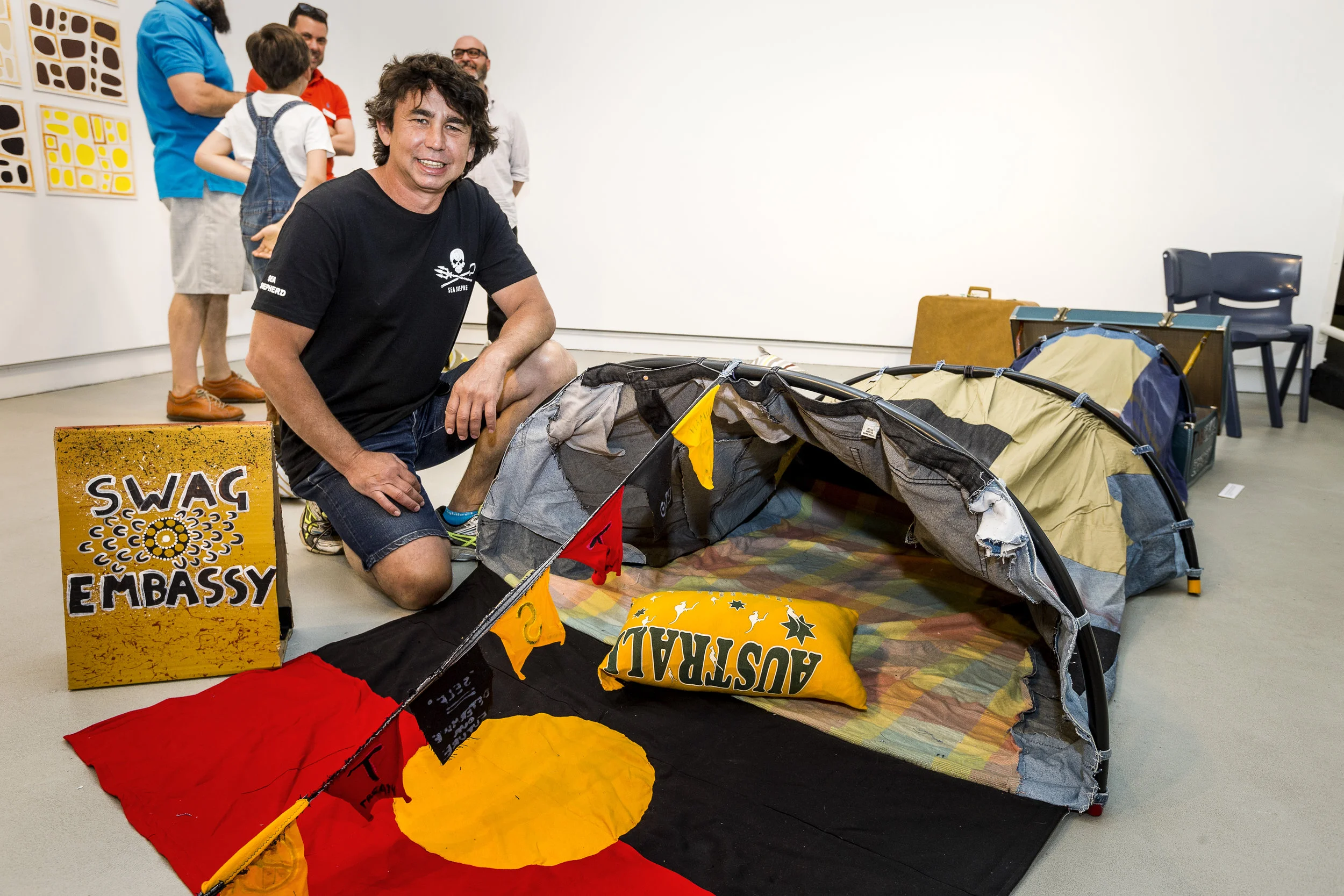 Christopher Burthurmarr Crebbin with his artwork  Swag Embassy , installation view, Prospect Gallery, 2015. Photograph John Nieddu