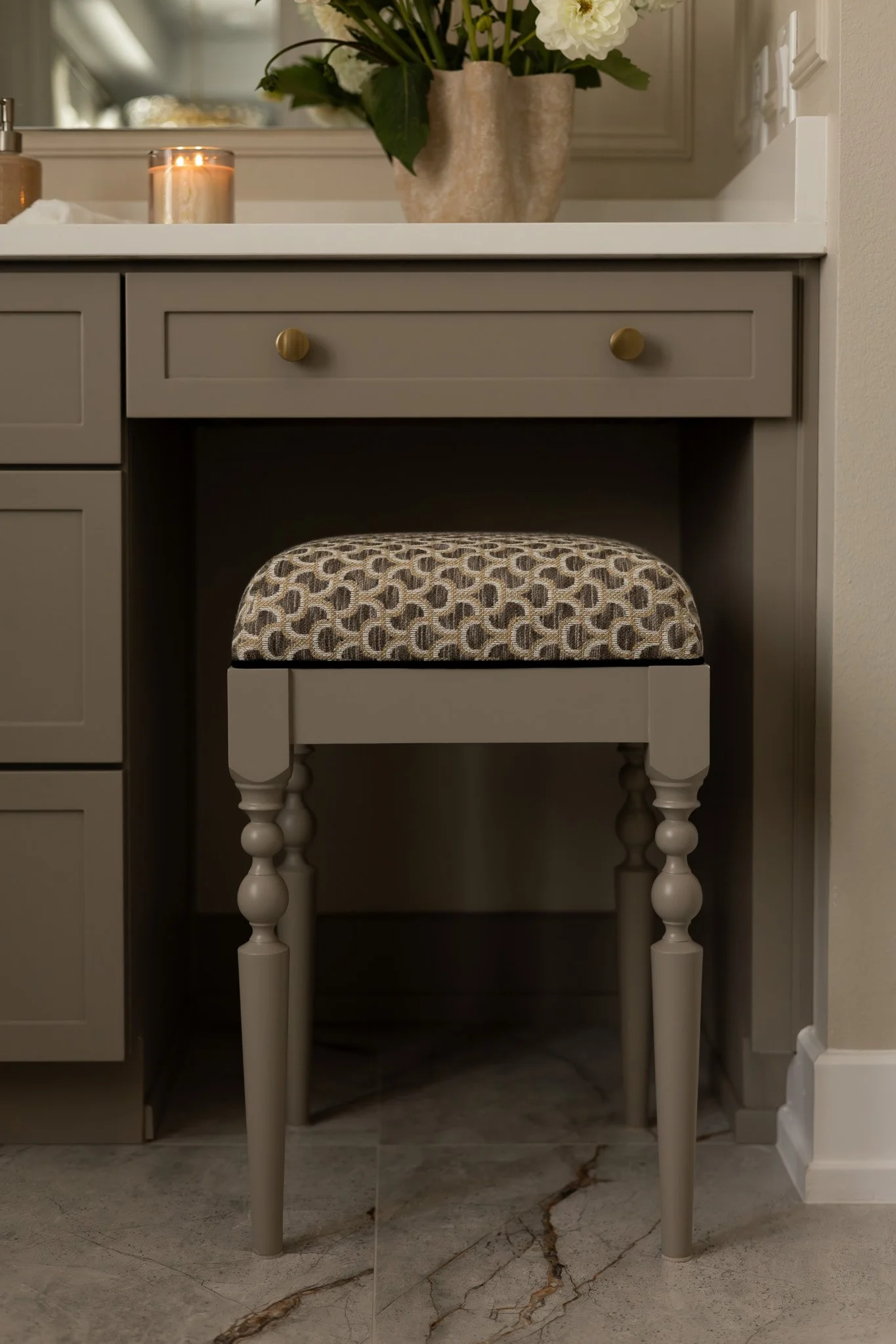 A custom vanity stool in a luxurious and sophisticated bathroom.