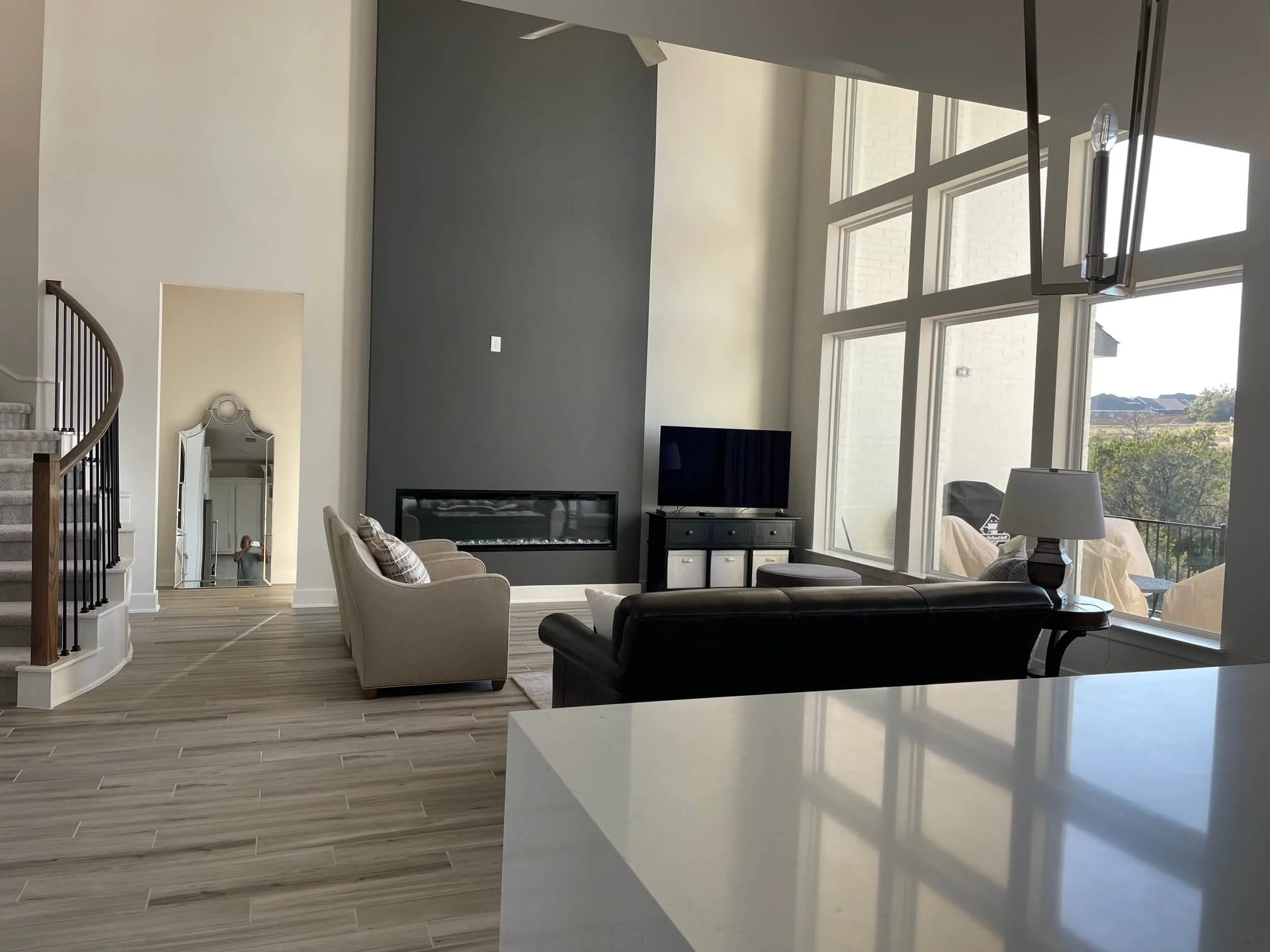 Builder-grade Austin TX home by Westin Homes before and after living room with tall ceilings and fireplace.