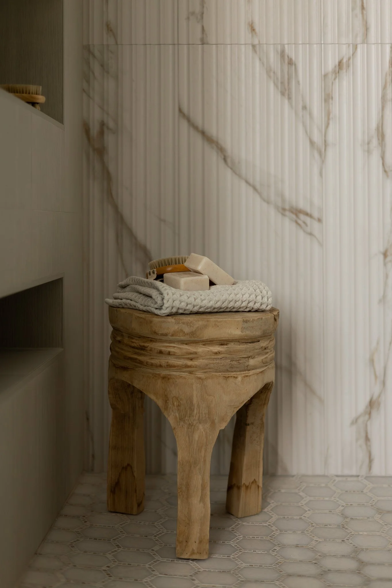 Elegant and sophisticated bathroom shower with reeded tile, multiple niches, marble shower pan tile.