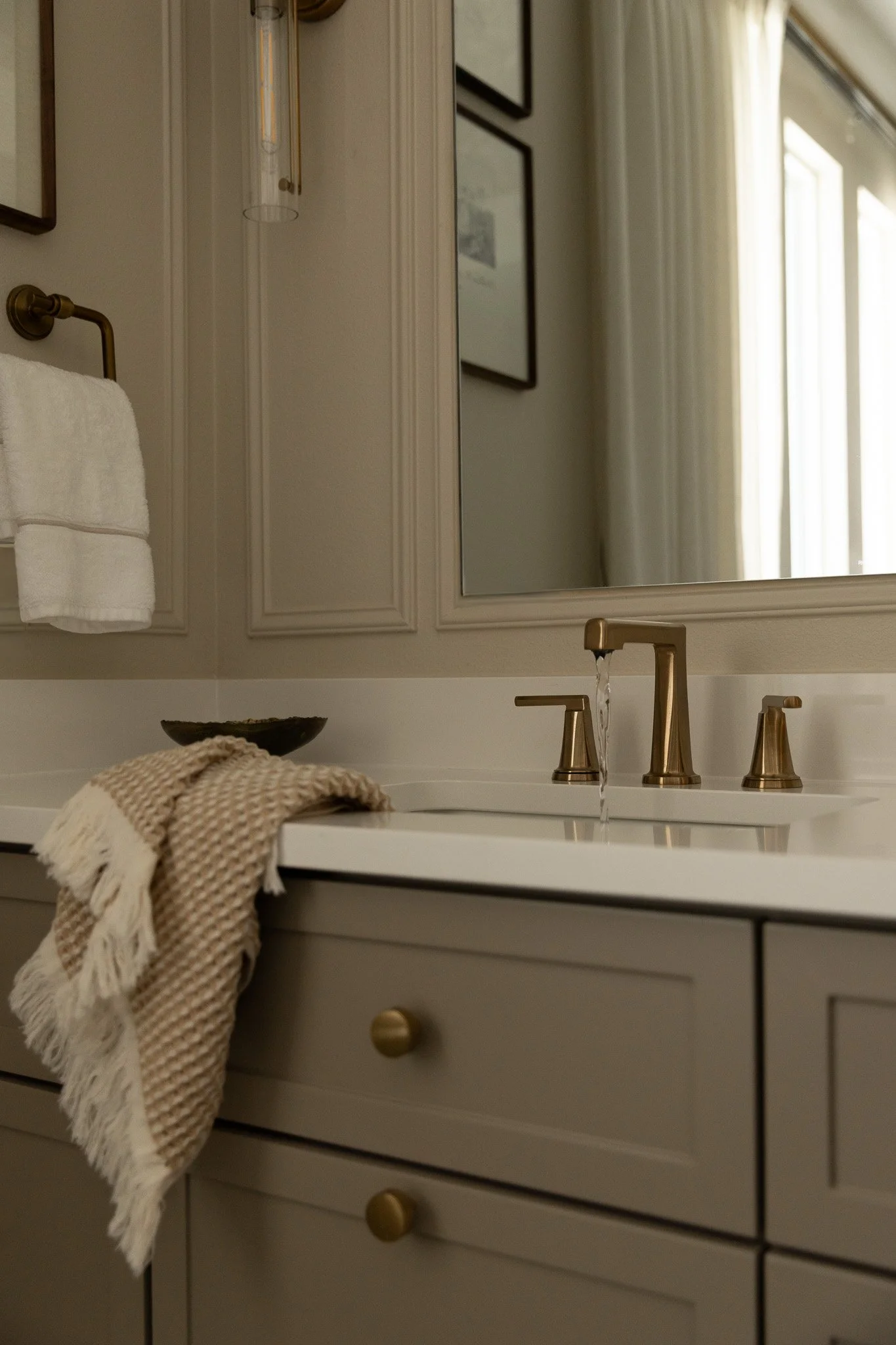 An elegant and sophisticated bathroom design with taupe cabinetry, romantic details and serene luxury feel.