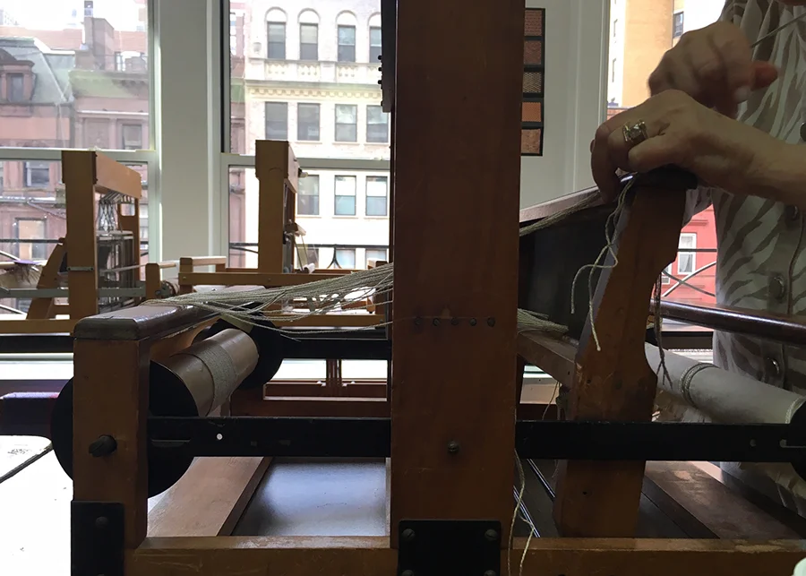 student dressing (threading) her loom in preparation to weave at the NCJWNY Council Lifetime Learning Center weaving studio, 2018