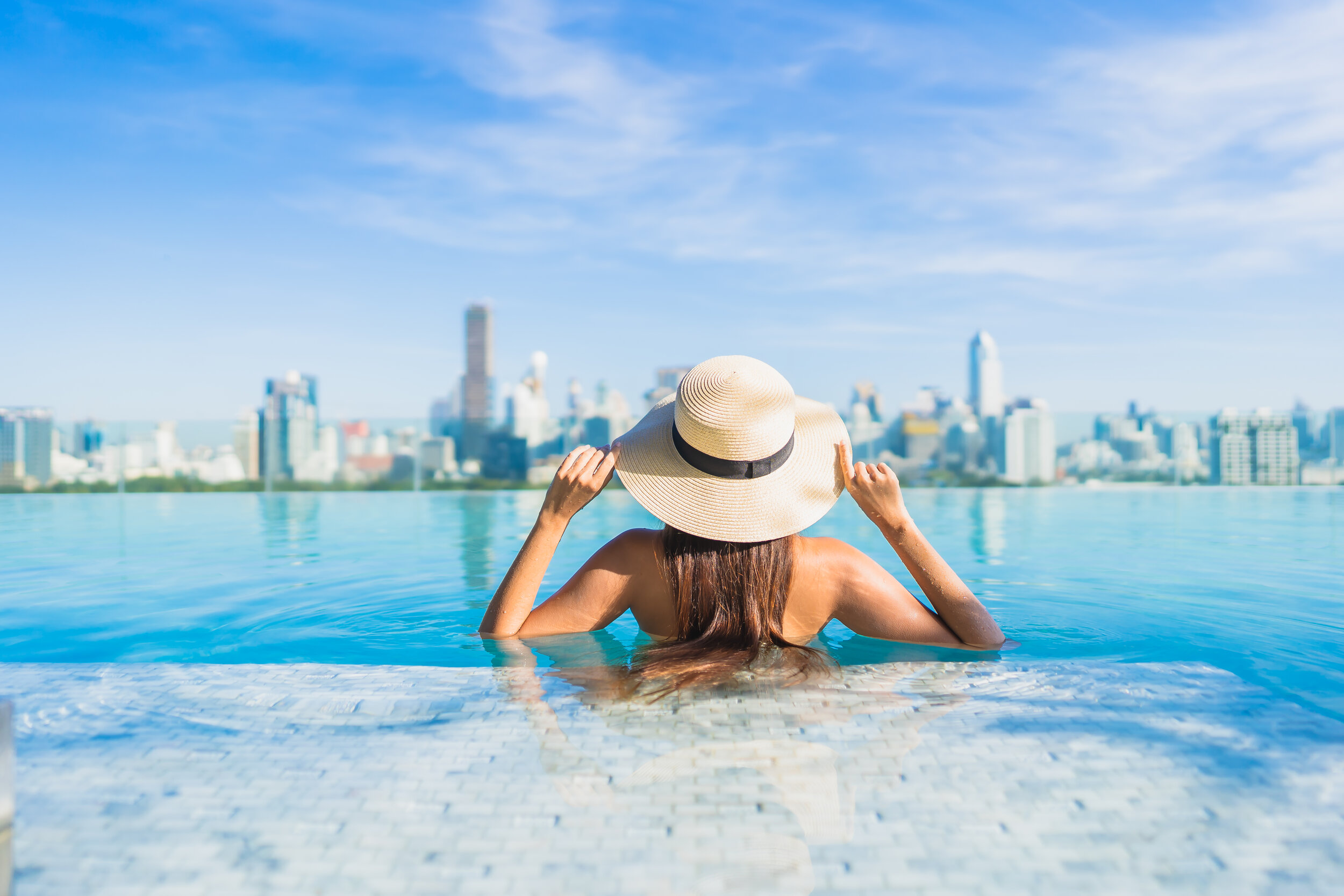 portrait-beautiful-young-asian-woman-relaxing-around-outdoor-swimming-pool-with-city-view.jpg