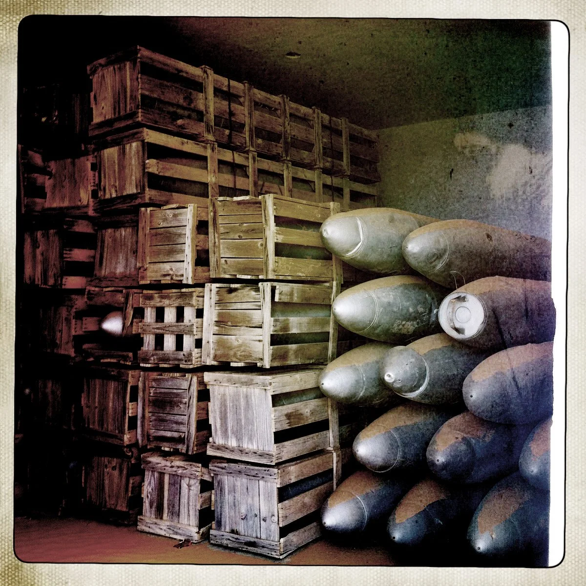 Libya Stacked wooden crates and several large bombs stored in a room.