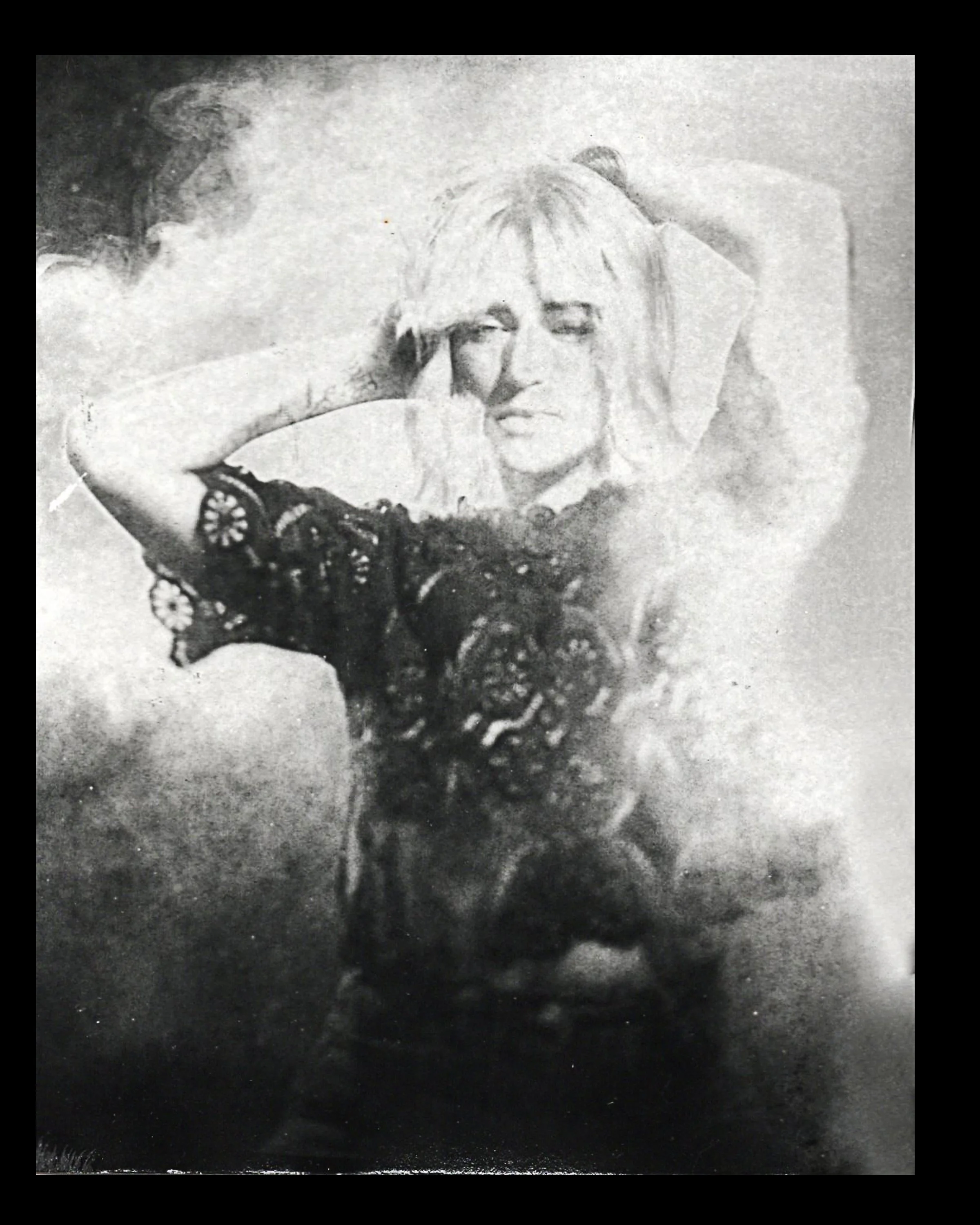 A woman with blonde hair and a solemn expression lying down with her hands behind her head, superimposed over a large face in the background.