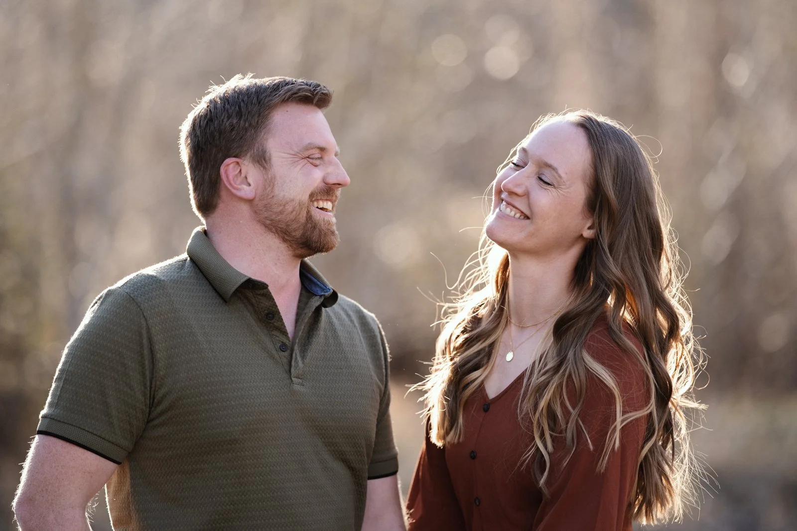 Couple laughing together during golden hour engagement photos near Red Lodge Montana