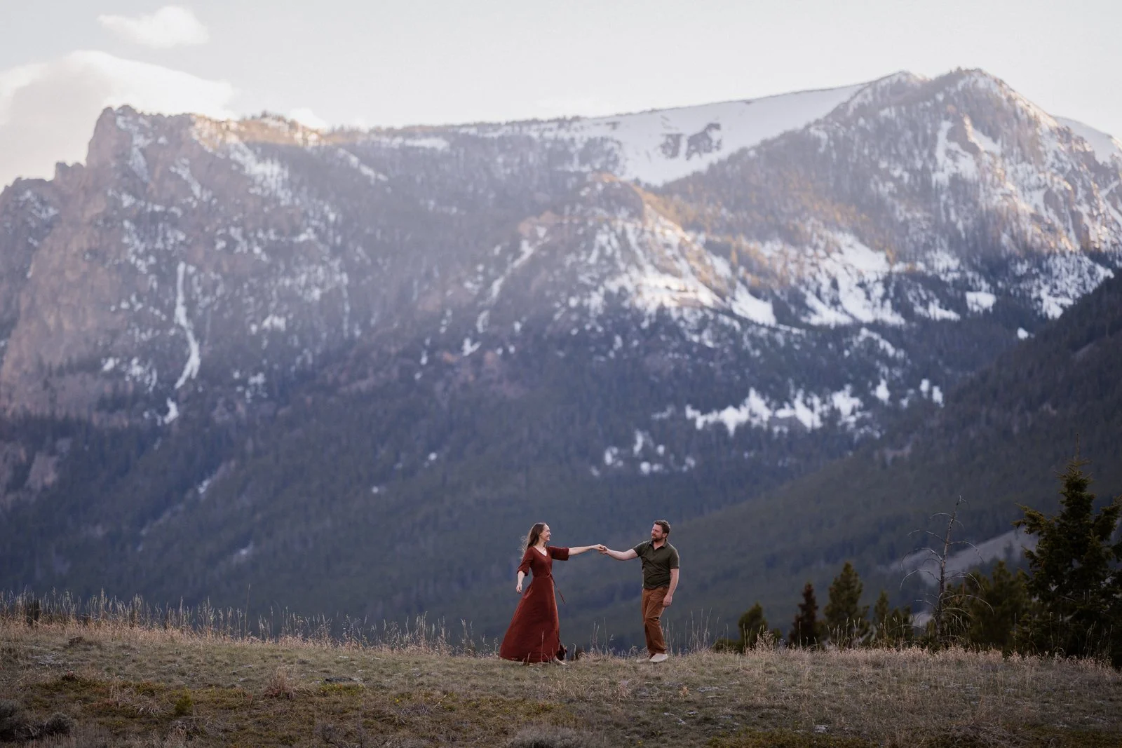 Couple holding hands during mountain engagement session near Beartooth Pass in Red Lodge Montana