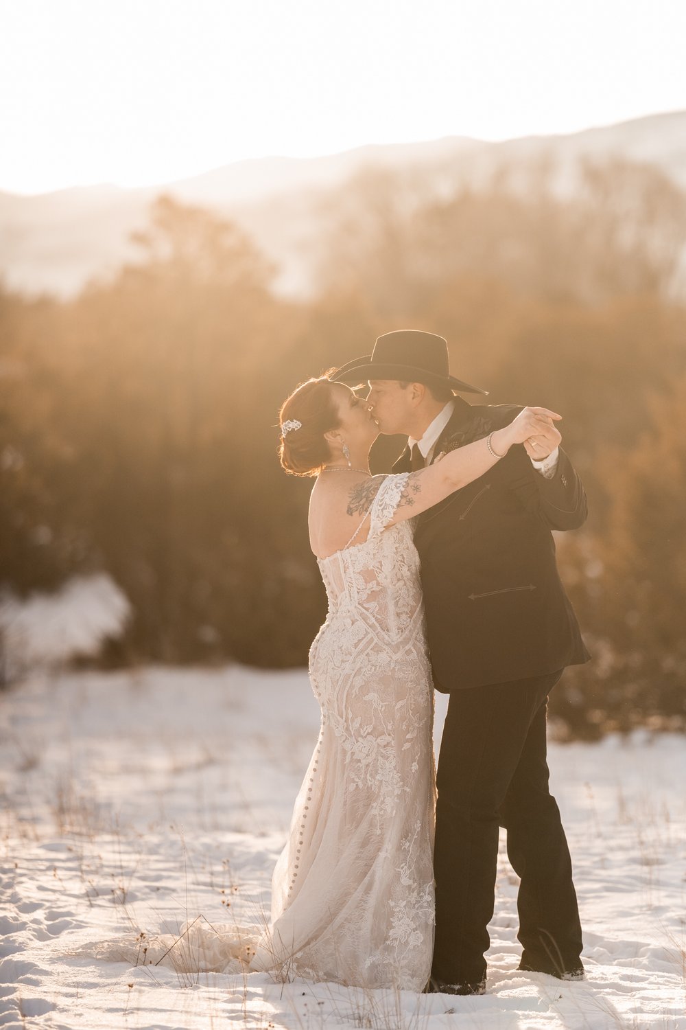 Winter wedding couple kiss in the snow.