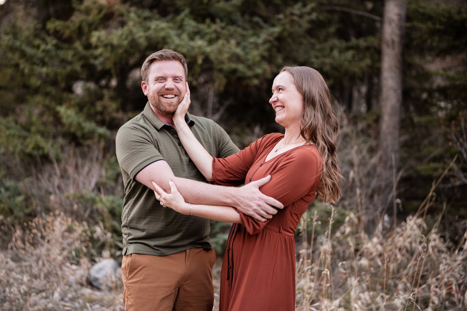 Playful couple laughing together during an engagement session in the mountains near Red Lodge Montana
