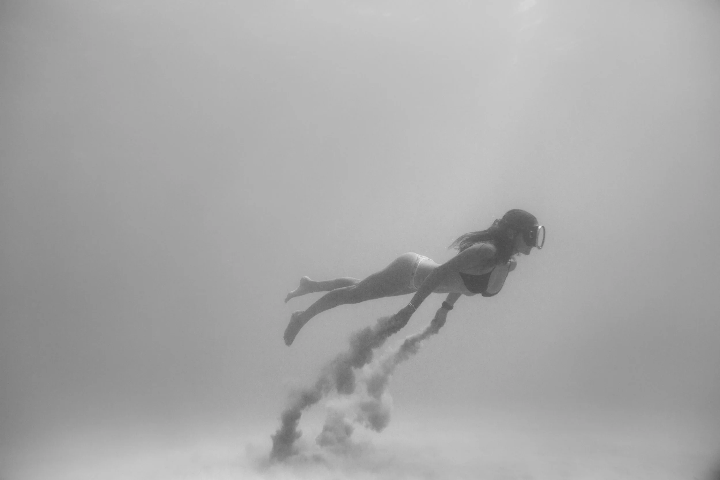 Freediver gliding over the seabed, black and white