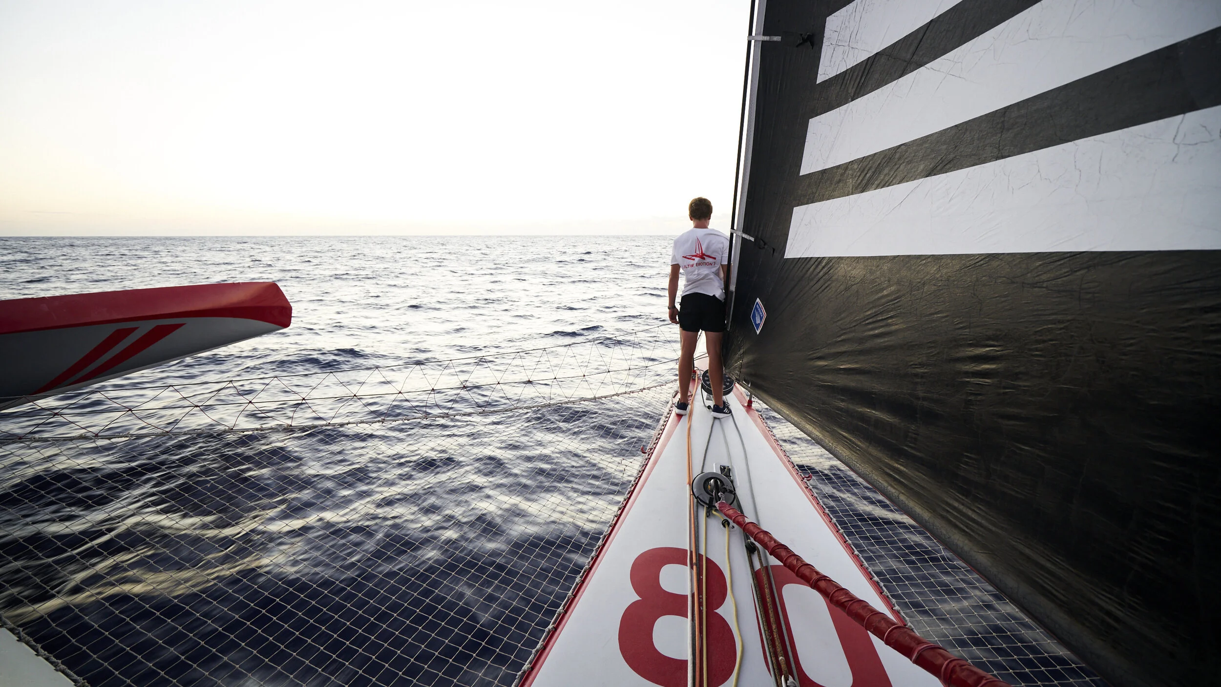 Sailor on the bow of a racing trimaran offshore
