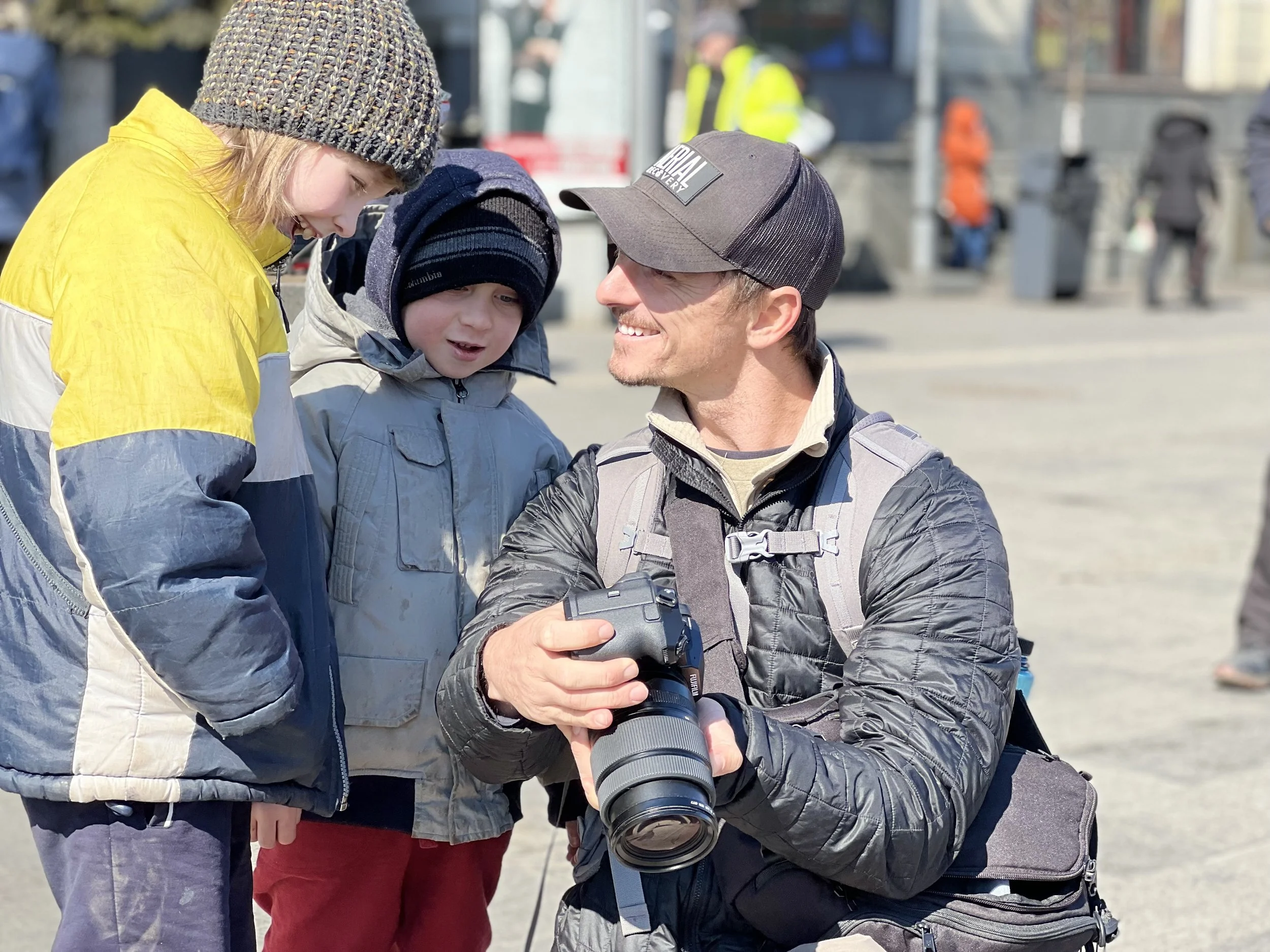 Marco Bava showing his camera to two children in the field