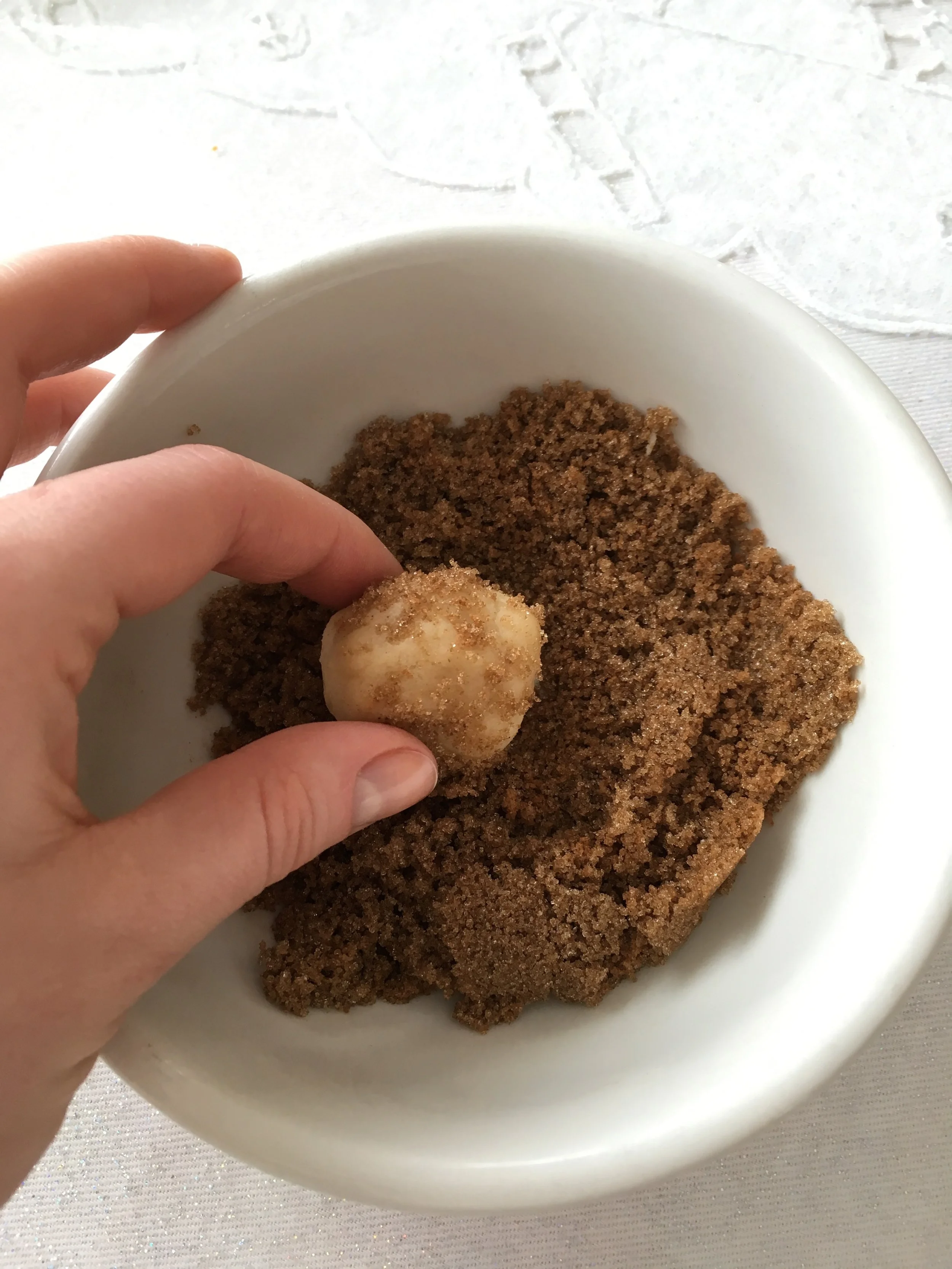 Dipping the balls of cooking dough in the cinnamon coating