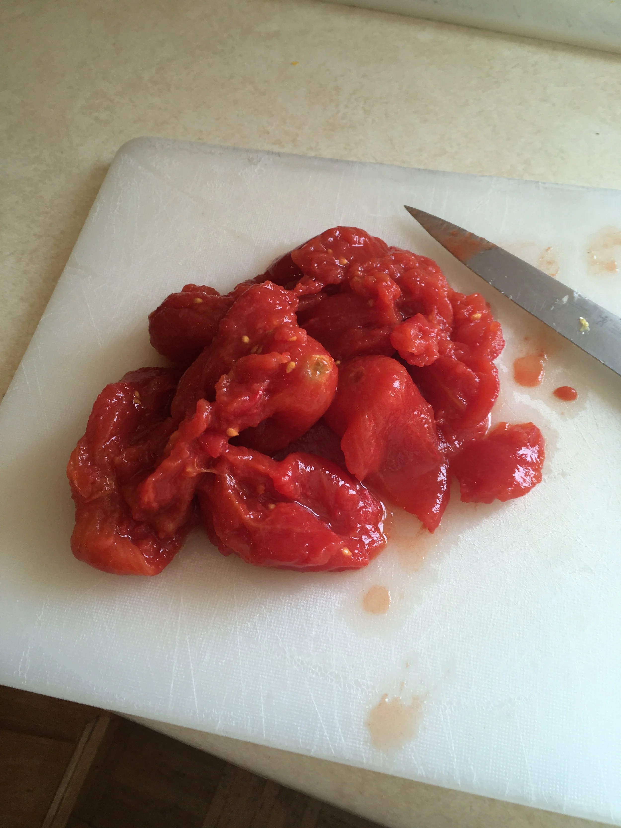 After removing the liquid from the tin, pour out the whole tomatoes and chop