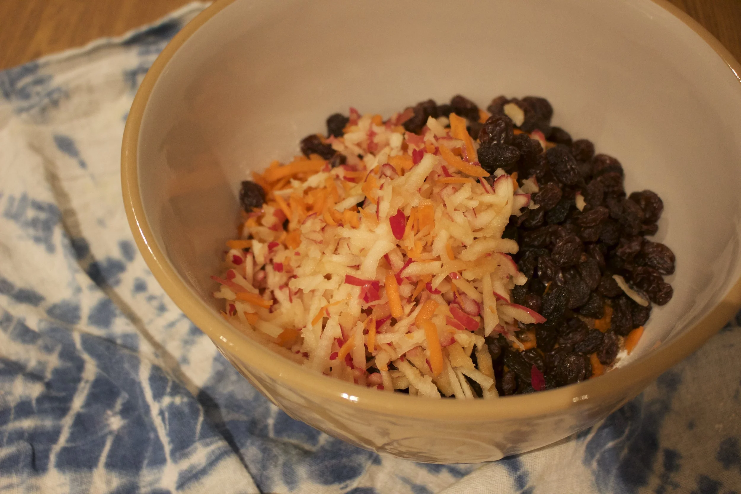 Mixing the dry ingredients with the raisins, apple and carrots