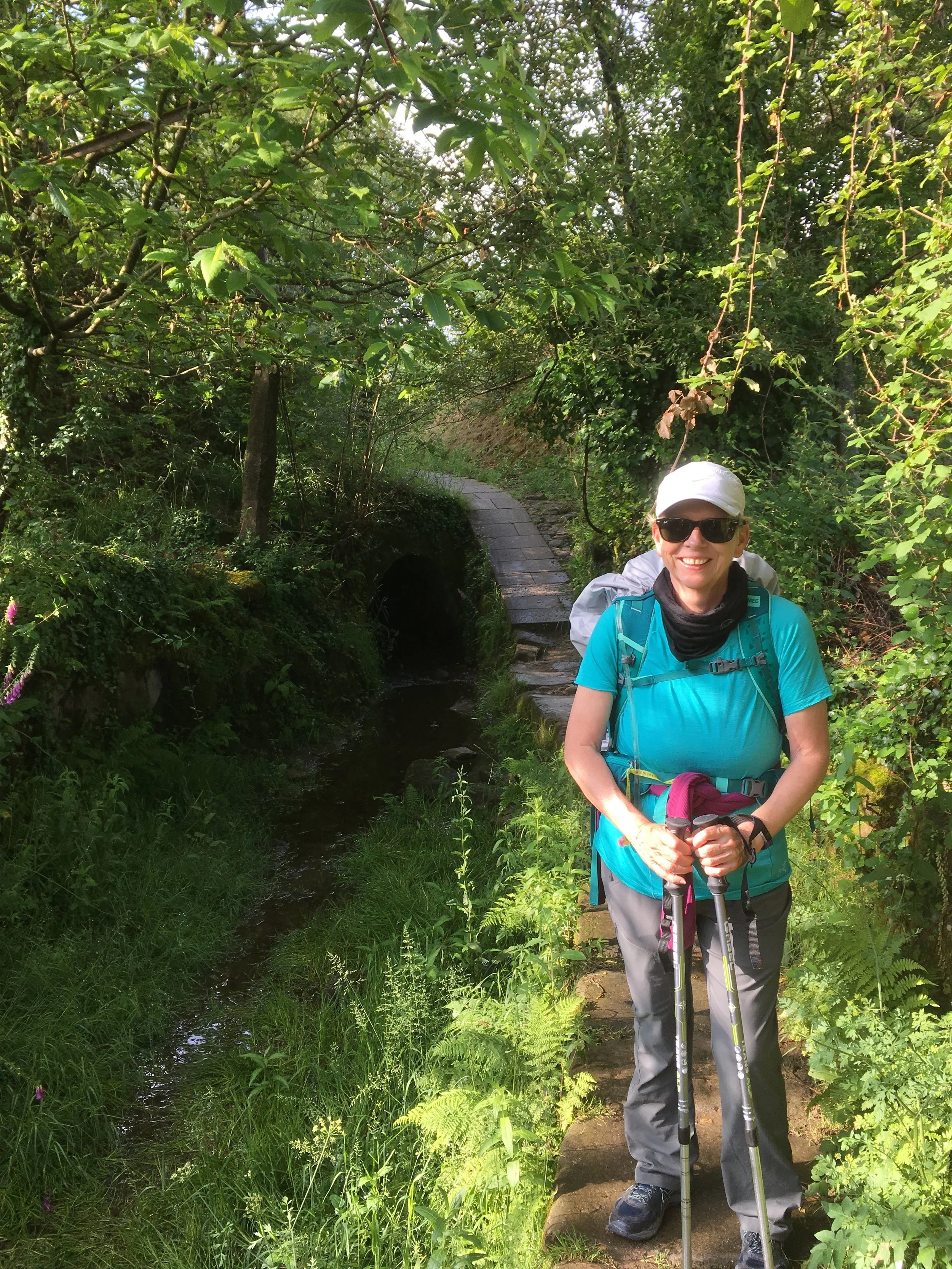 My mum crossing a little sidewalk next to a ditch that often has flowing water through it