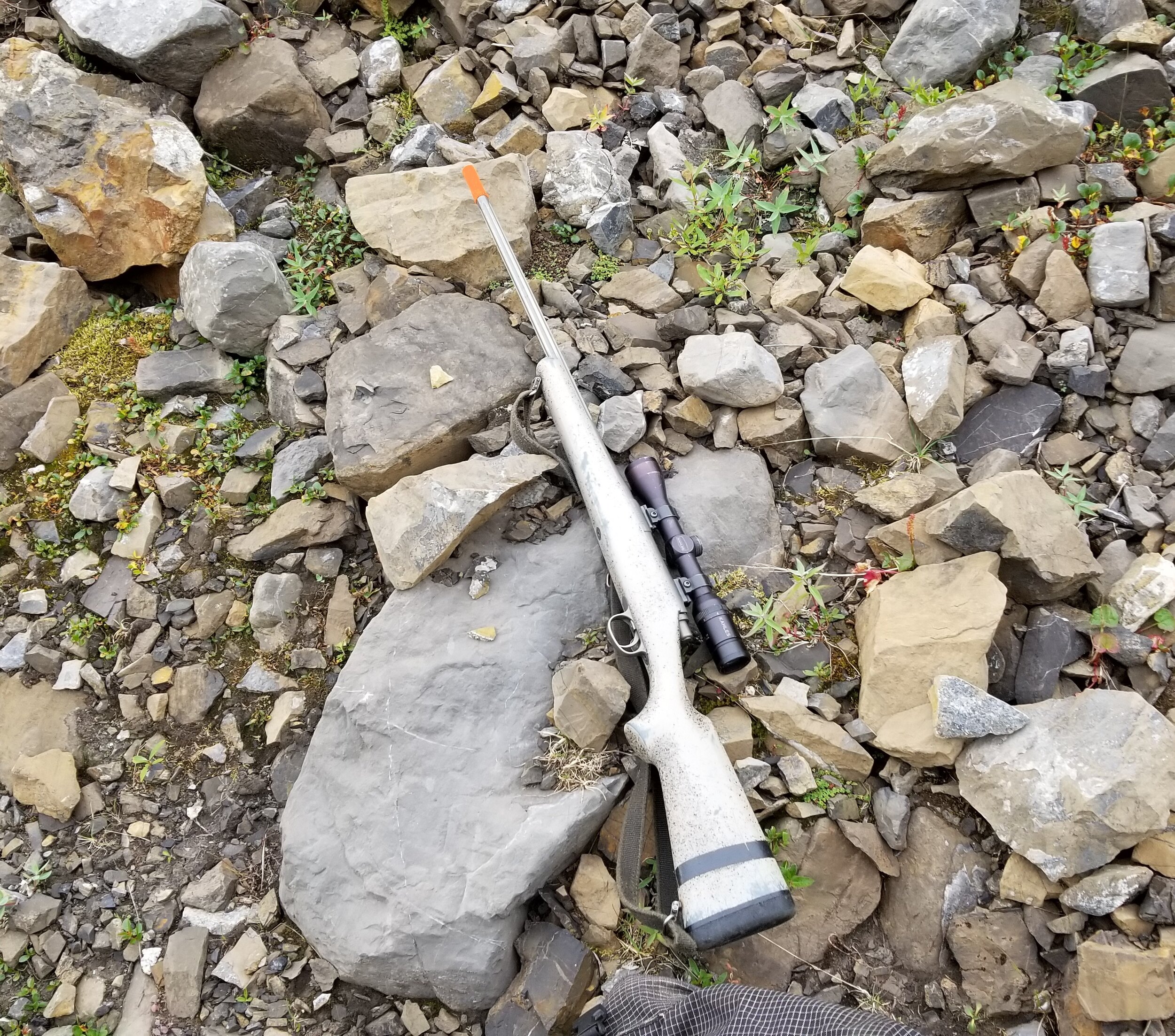 Rifle on rocks with muzzle cover square.jpg