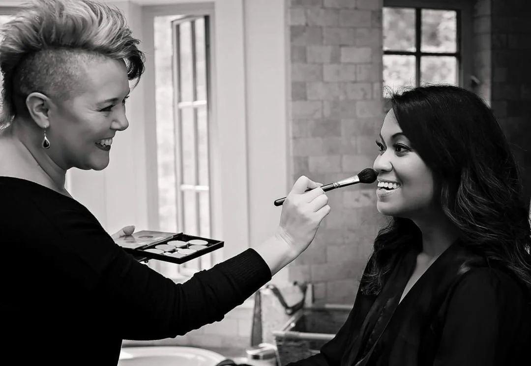 Makeup artist applying powder with a brush to a client