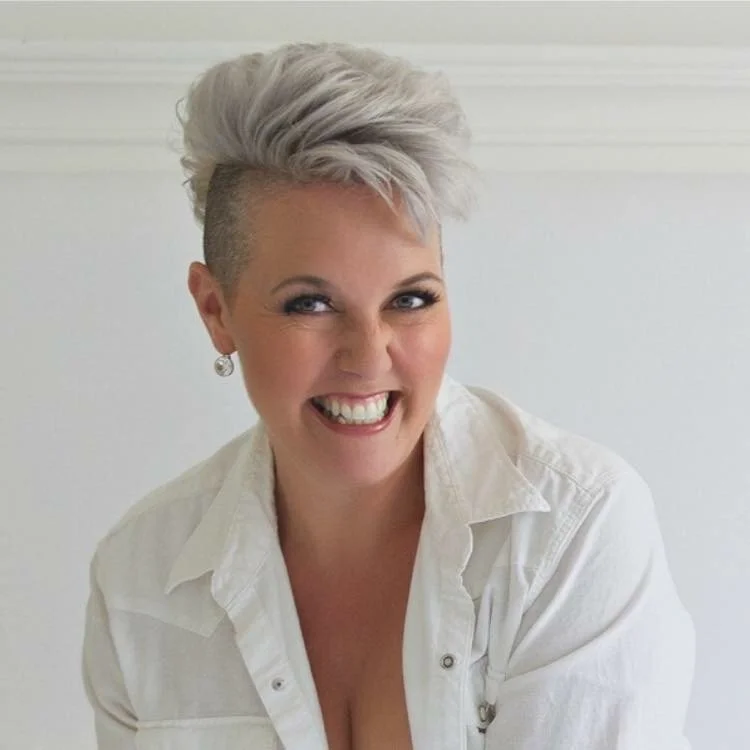 Woman over 50 in a white collared shirt, smiling