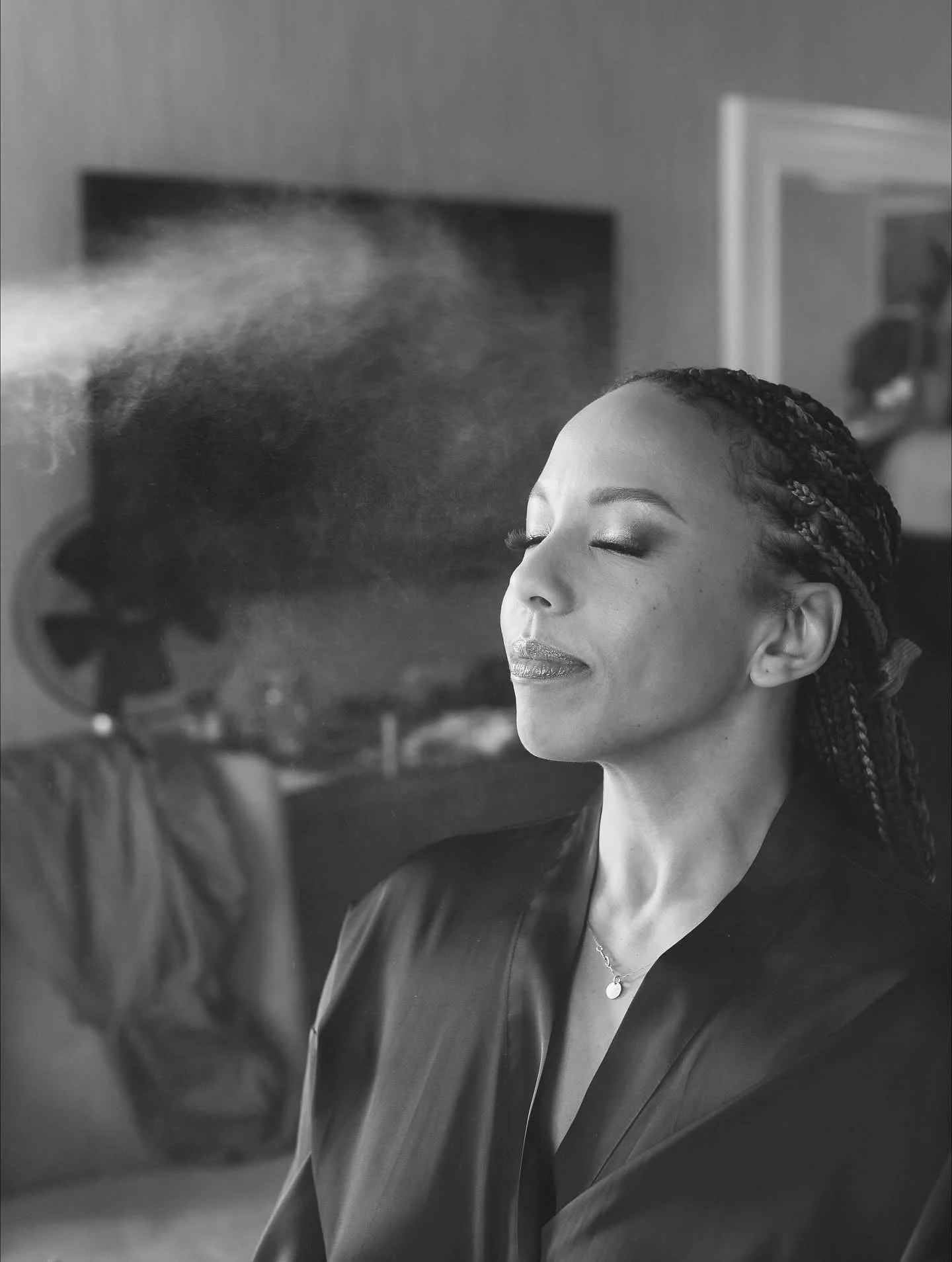 Makeup artist applying setting spray to client's face