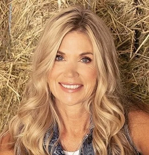 Woman with clear, natural makeup smiling outdoors